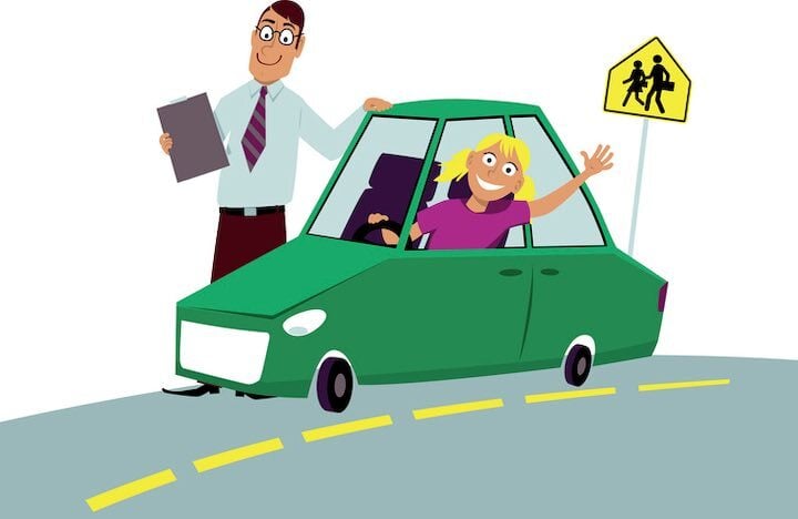 Instructor stands beside a teen driver during a driving lesson