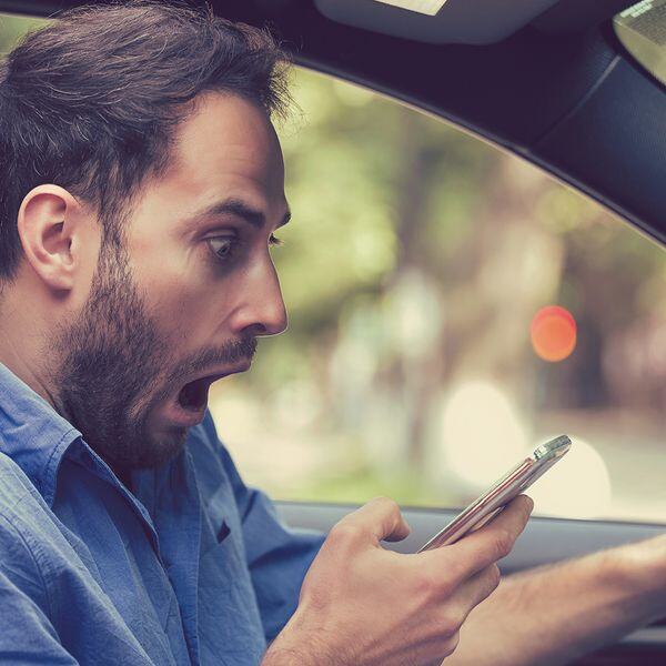 Image of a checking his phone in his car Image of a checking his phone in his car