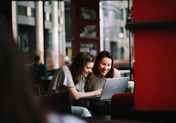 Mother daughter on laptop in cafe