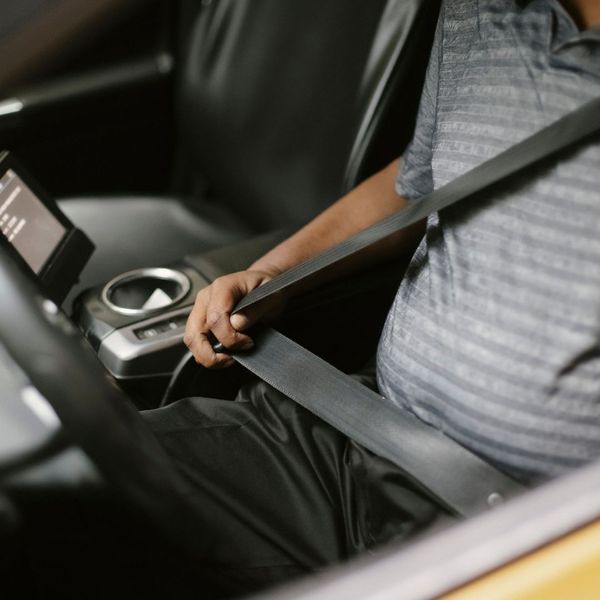 person buckling seatbelt