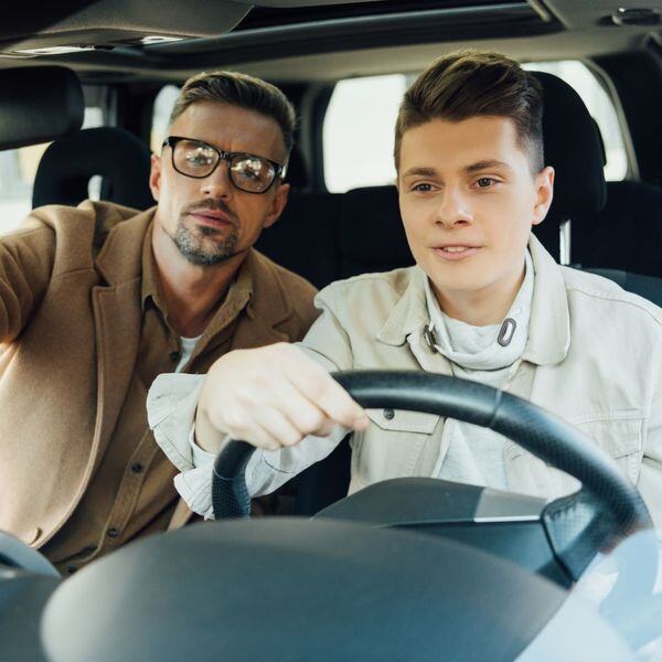 Father and son practicing driving a car